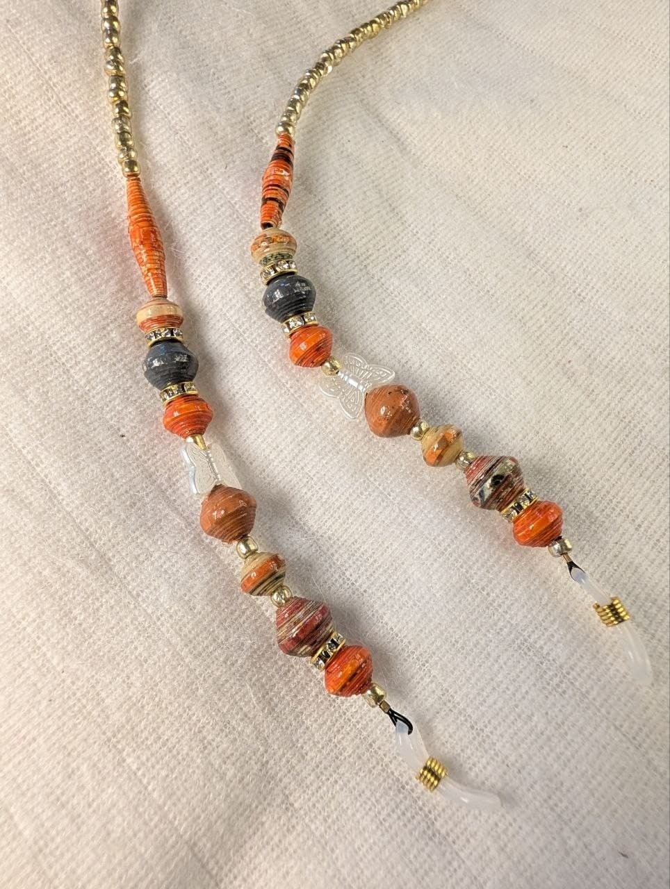 Red rolled paper bead eyeglass holder on a bright green cord with gold-tone lobster clasps view 2