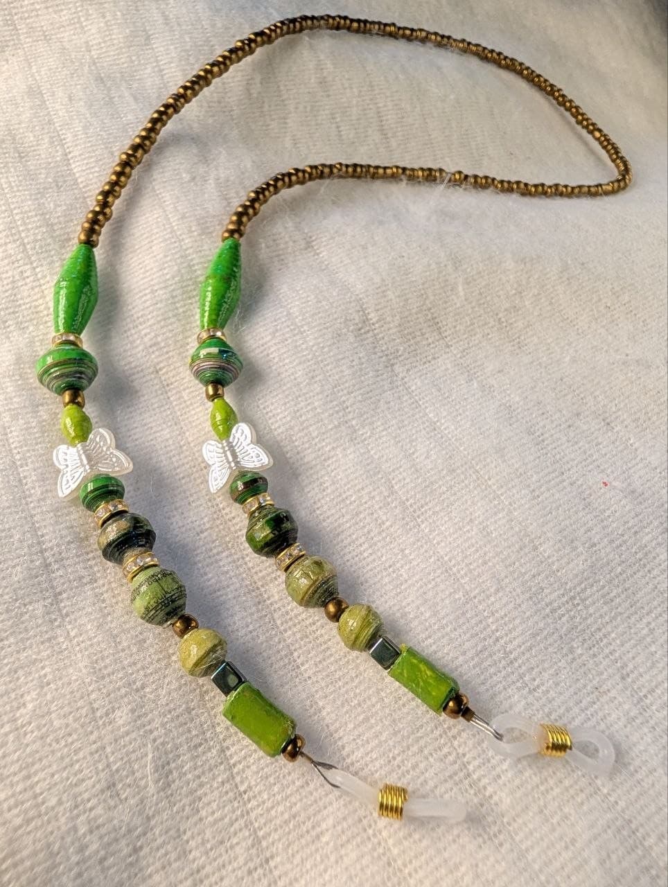 Red rolled paper bead eyeglass holder on a bright green cord with gold-tone lobster clasps