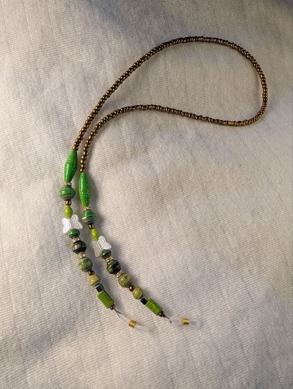 Red rolled paper bead eyeglass holder on a bright green cord with gold-tone lobster clasps view 6