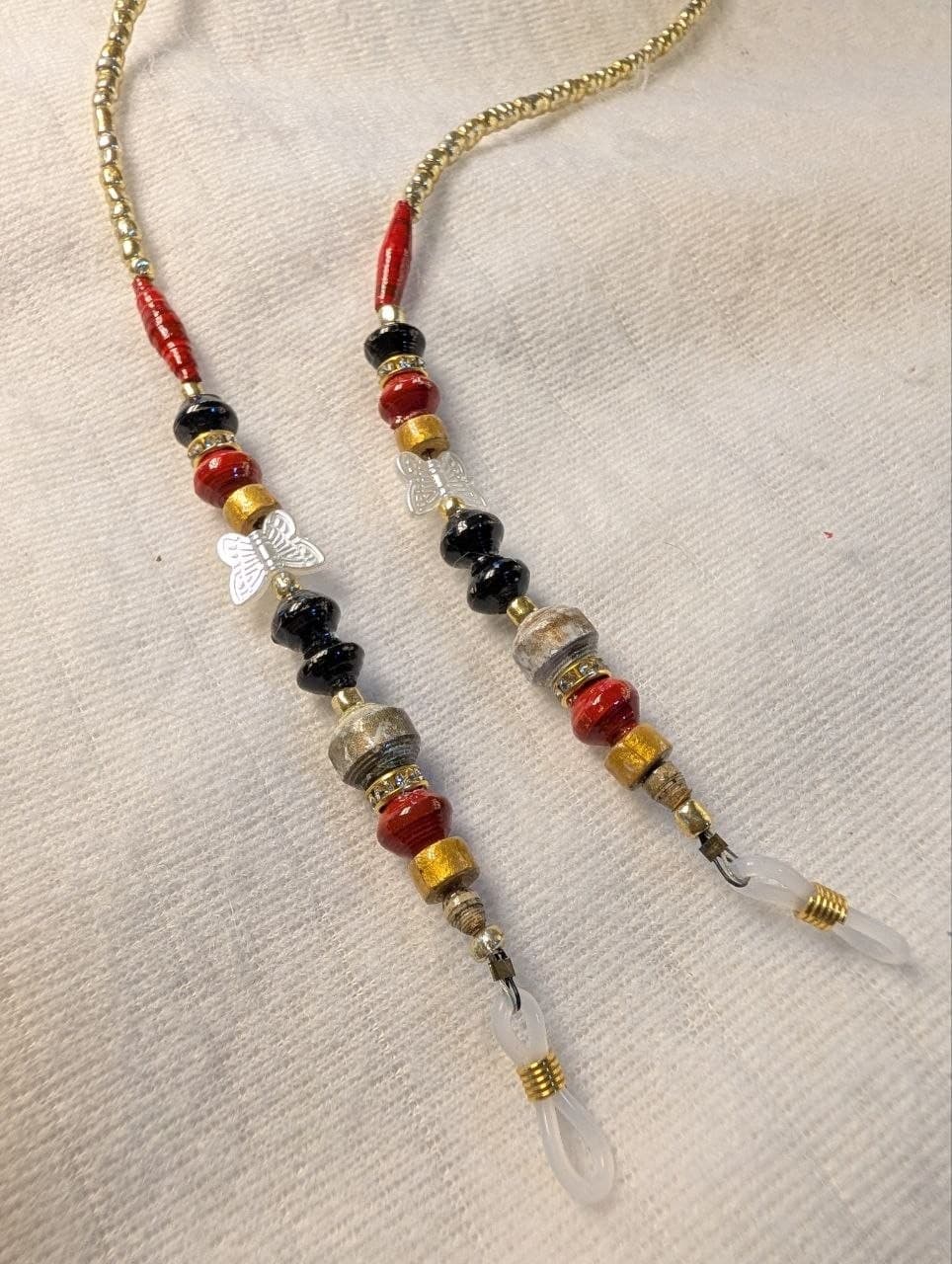 Red rolled paper bead eyeglass holder on a bright green cord with gold-tone lobster clasps view 4
