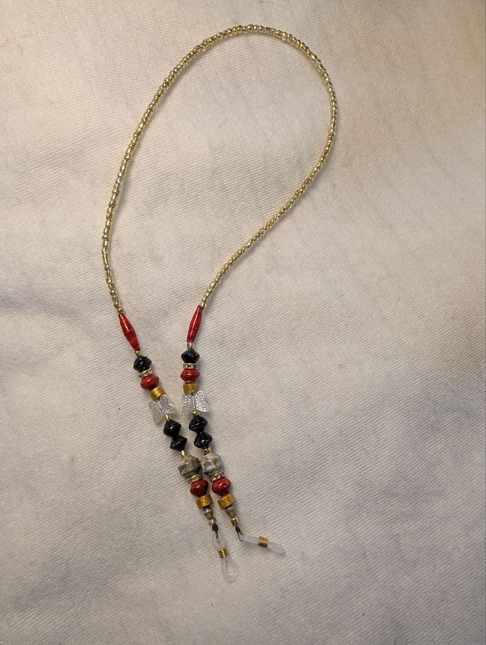 Red rolled paper bead eyeglass holder on a bright green cord with gold-tone lobster clasps view 5